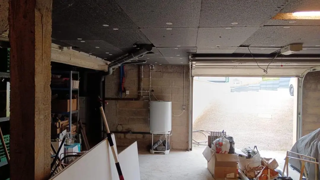 Chauffe-eau installé dans un garage avec réseaux apparents