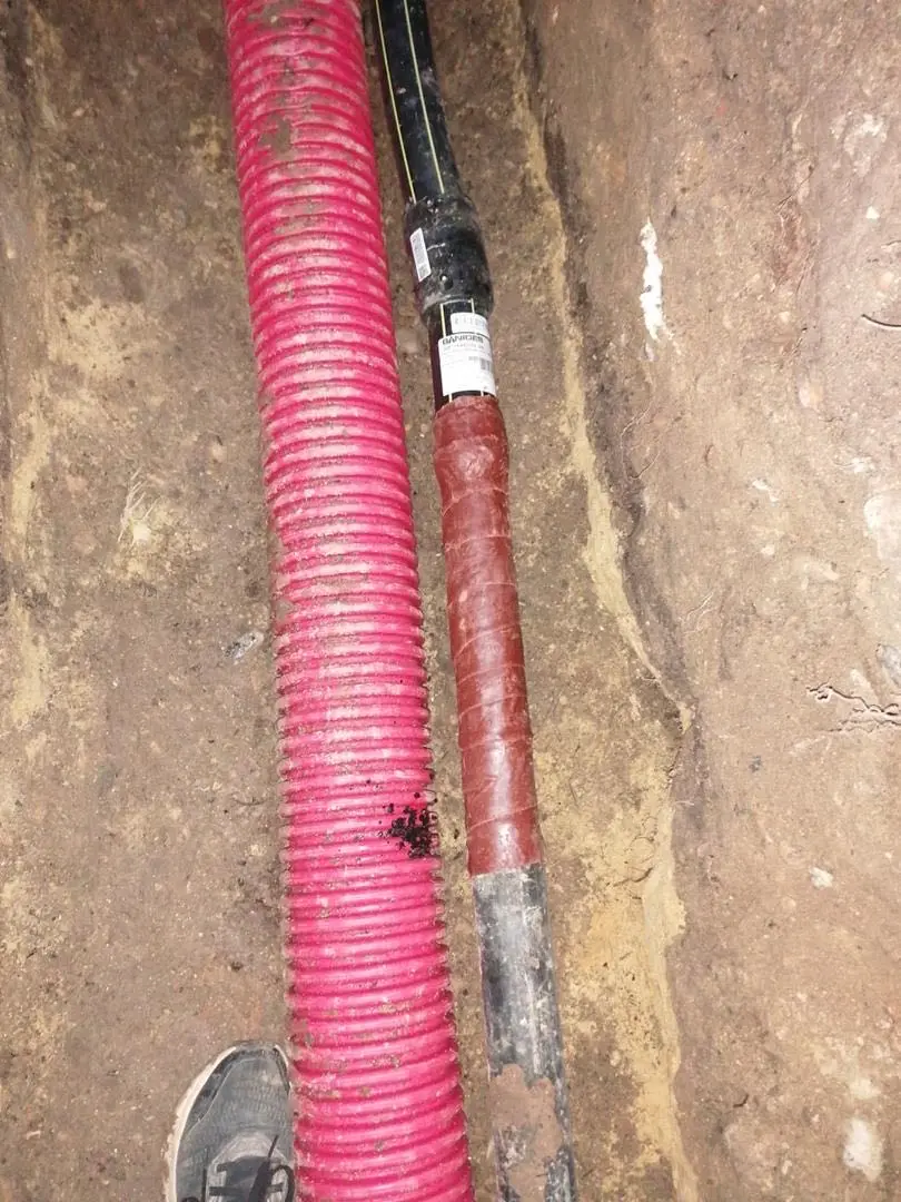 Canalisation de gaz gainée dans une tranchée avec gaine rouge de protection